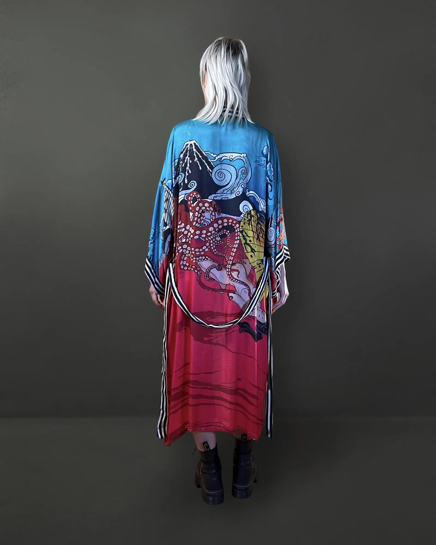 Back view showing the flowing red Cupro Bemberg fabric with artistic illustrations