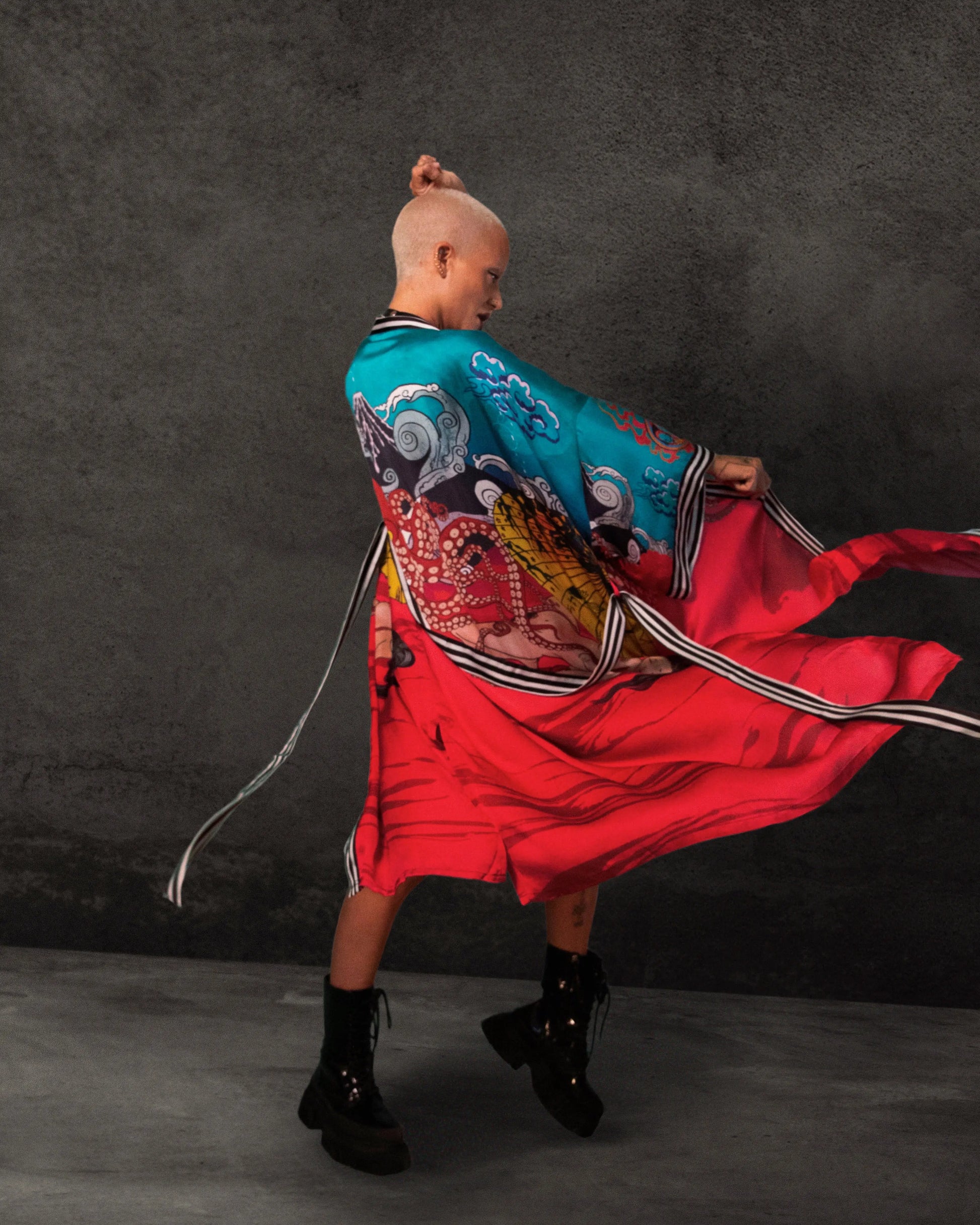 Back view showing the flowing red Cupro Bemberg fabric with artistic illustrations